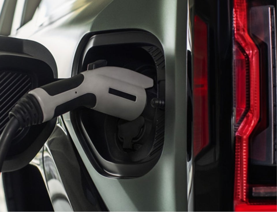 Close up of charging port with charger plugged in on a GMC Hummer EV SUV - Capitol City GMC in Berlin VT